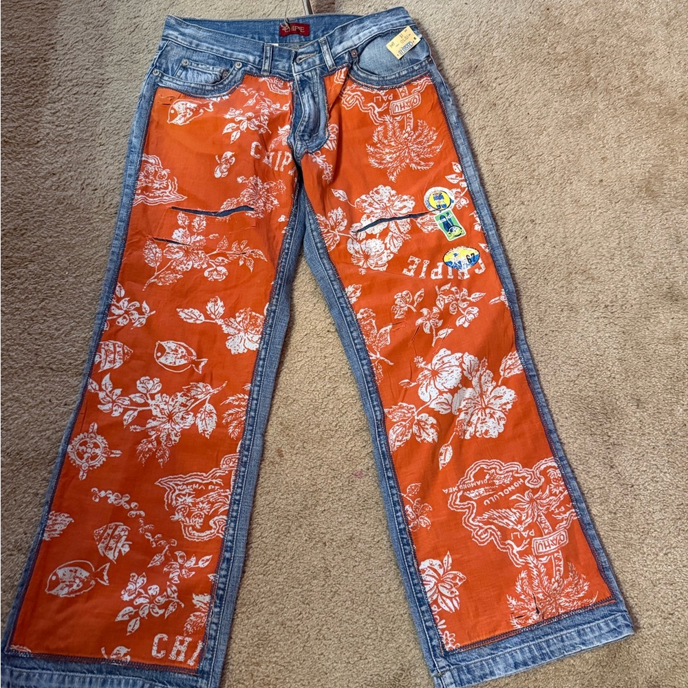 Chipie flared wider leg blue jeans with orange tropical print on the front.